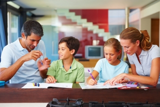 Children being helped by their parents with homework